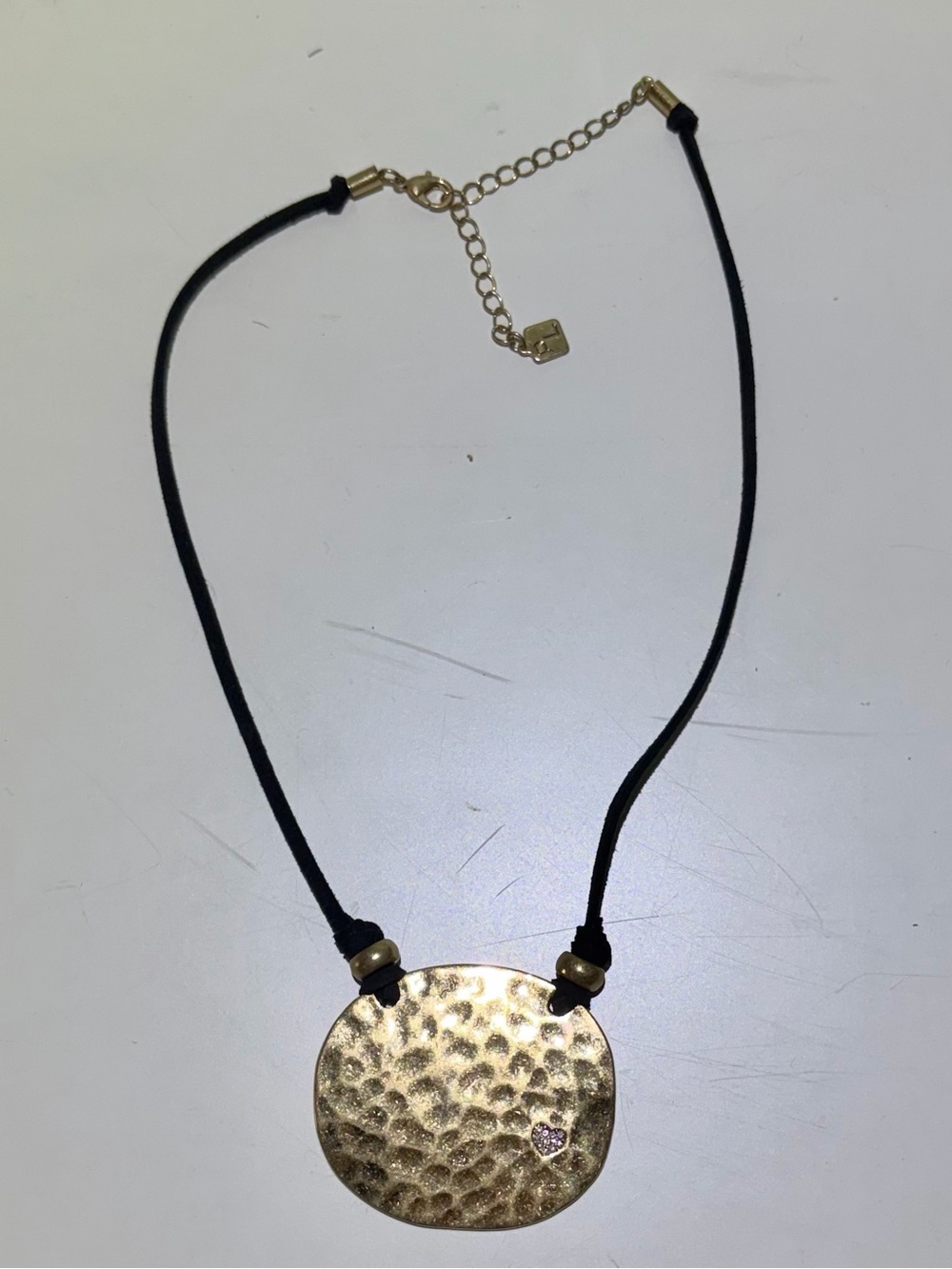 Park Lane Gold Hammered Disc Pendant Necklace with Black Cord. 19” Length